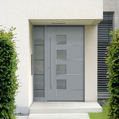 Eine graue Tür mit Pflanzen an den Seiten, die sehr einladend wirken